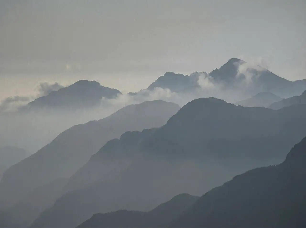 soft gray mountains in morning mist, layered silhouettes, atmospheric depth, minimal scenic wallpaper