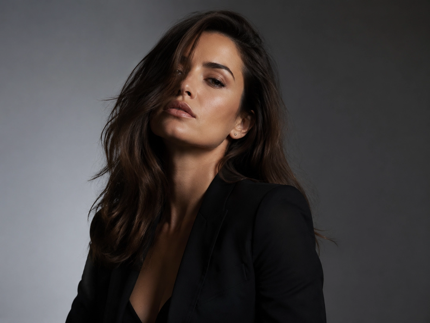 Minimal studio portrait of an adult woman in a sleek monochrome outfit, dramatic side lighting, clean background, subtle seductive expression, luxury campaign style, photorealistic finish