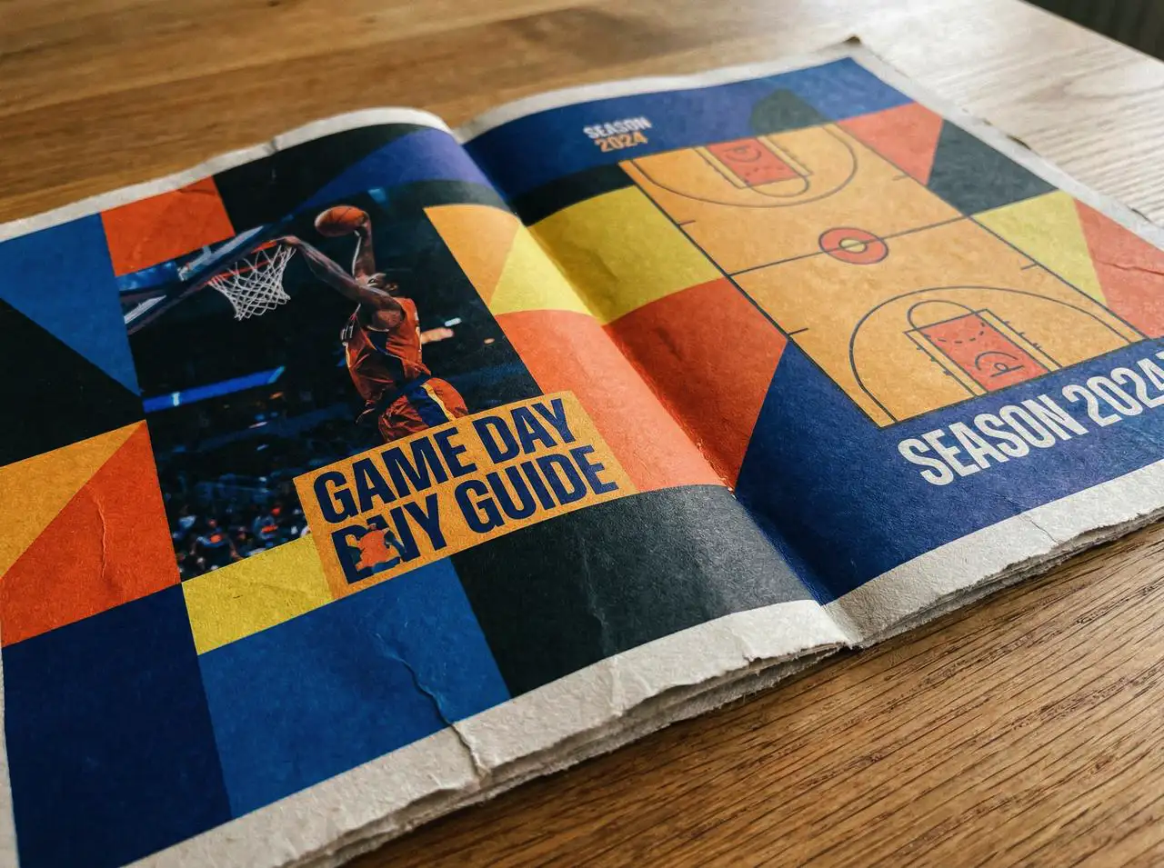 Basketball booklet layout in close-up, strong colors and geometric divisions, realistic paper texture.