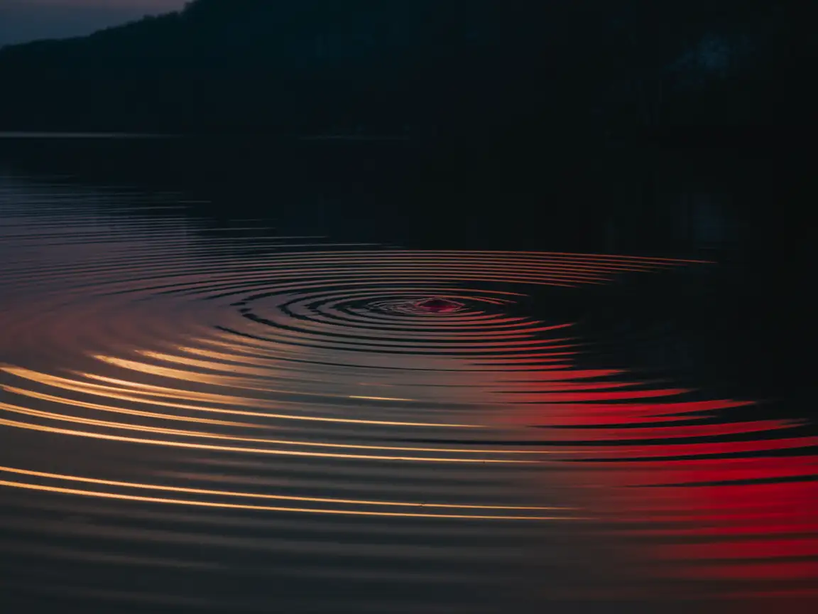Red ripple effect on a water surface with subtle highlights.